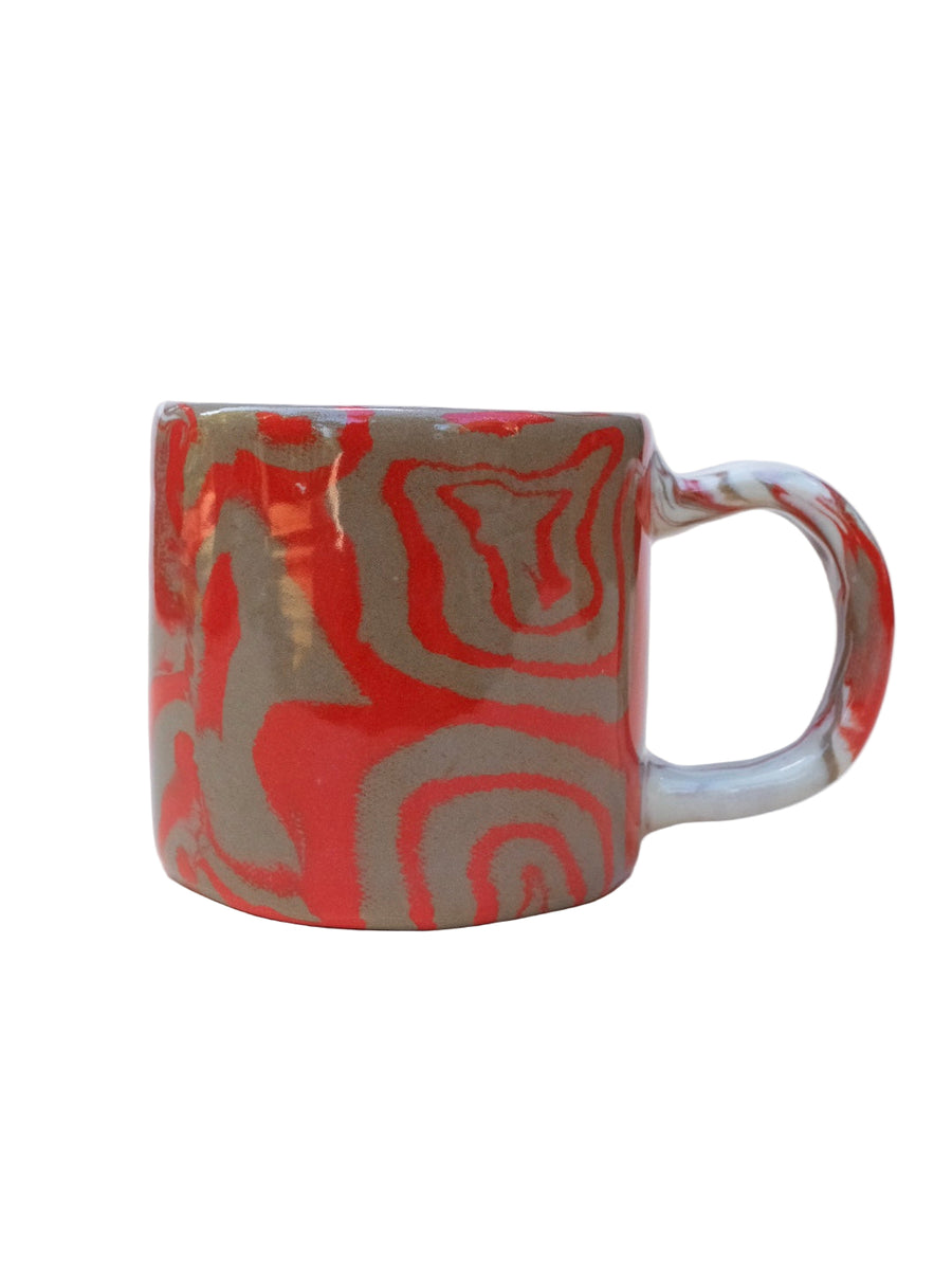 Nerikomi Ceramic mug with red and fawn abstract spirals pattern on a white background