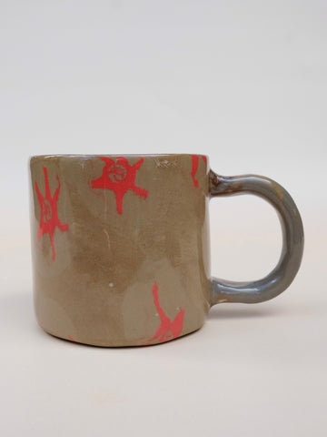 Ceramic mug with red abstract designs on a white background