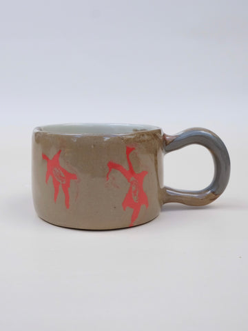 Brown mug with red abstract designs on a white background